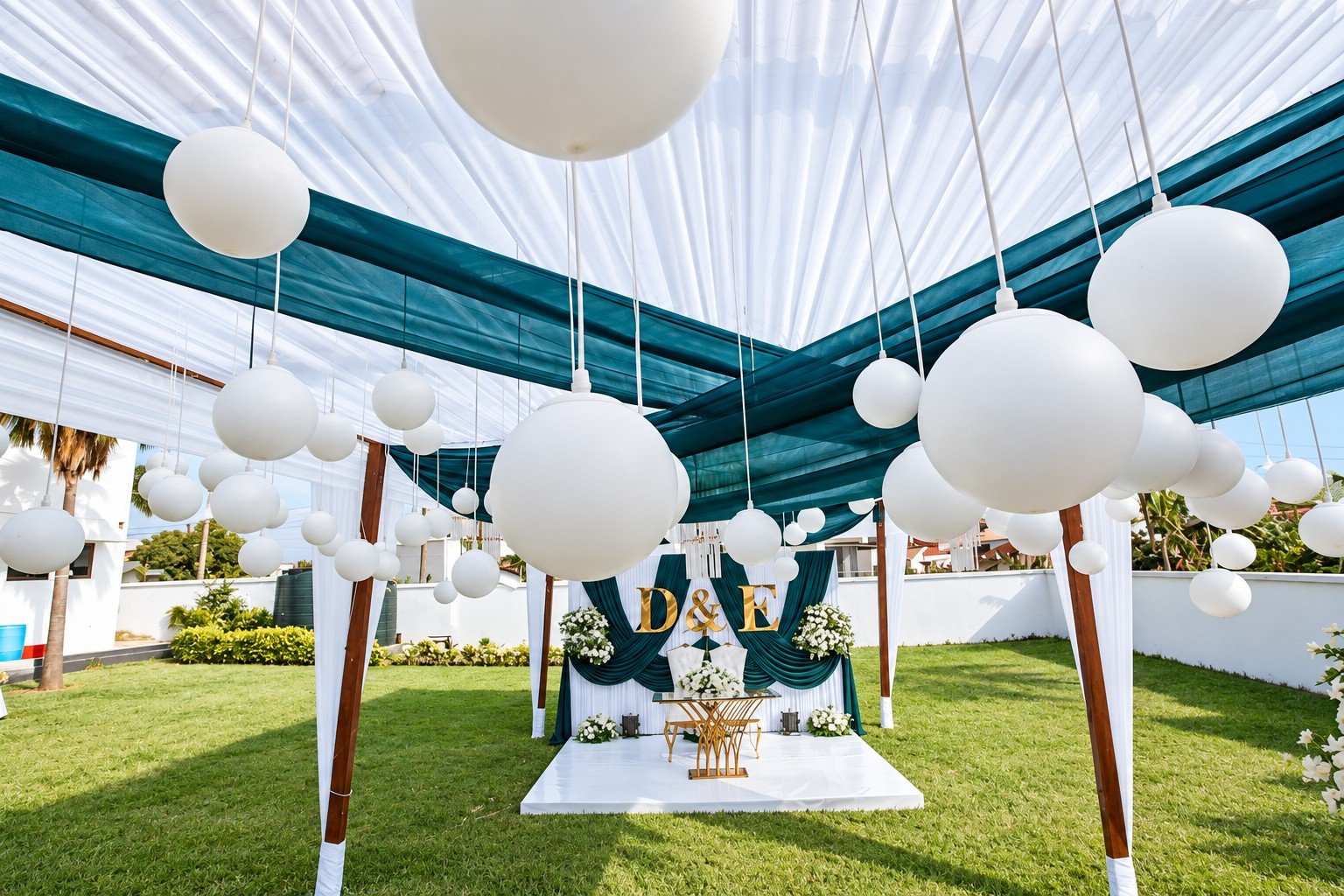 Teal and white wedding canopy with hanging lanterns and a floral backdrop at Donna’s Place